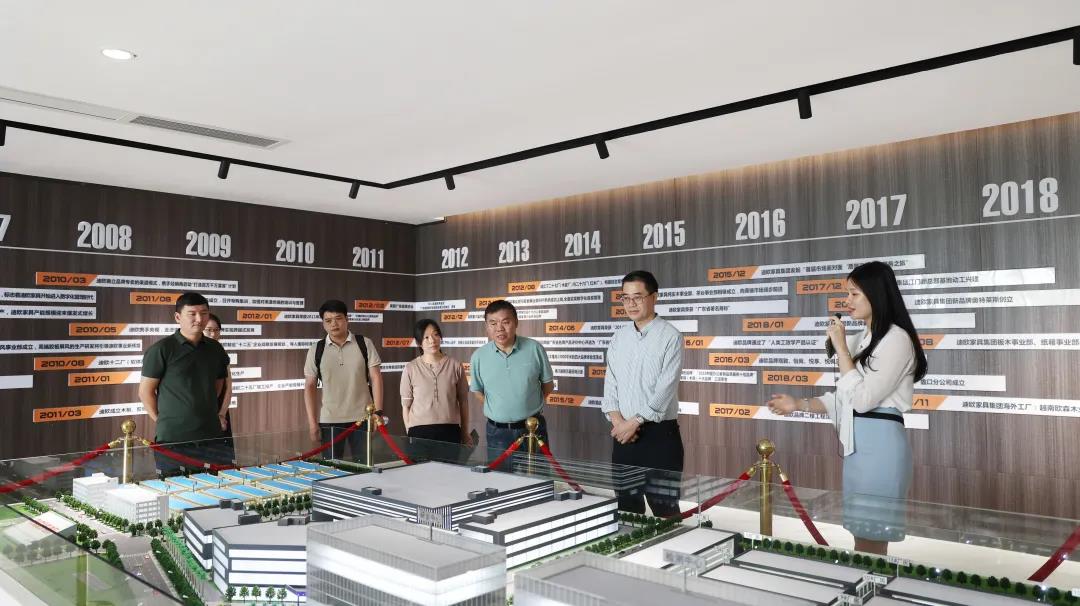 在沙盘前，工作人员为王克会长讲解集团的发展规划